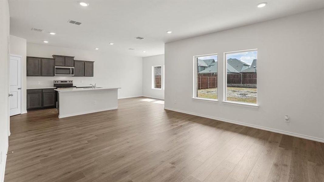 Open concept living space featuring light wood-style flooring, recessed lighting, and white walls