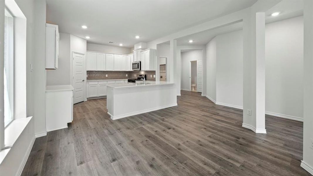 Kitchen featuring white cabinets, tasteful backsplash, recessed lighting, stainless steel appliances, and dark wood finished floors Kitchen featuring white cabinets, tasteful backsplash, recessed lighting, stainless steel appliances, and dark wood finished floors