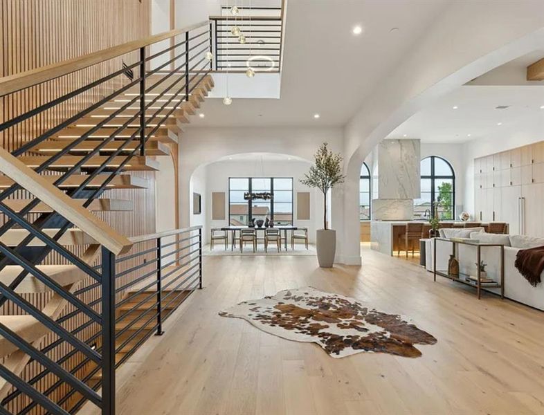 Entrance foyer featuring light wood-style floors, a chandelier, and arched walkways