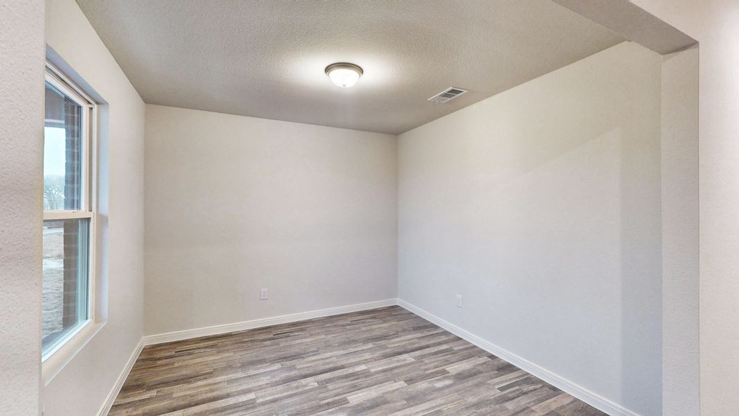 A room with a wood floor and windows.