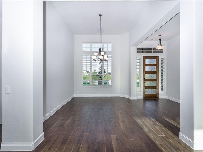 Foyer entrance featuring dark wood-style flooring and a chandelier