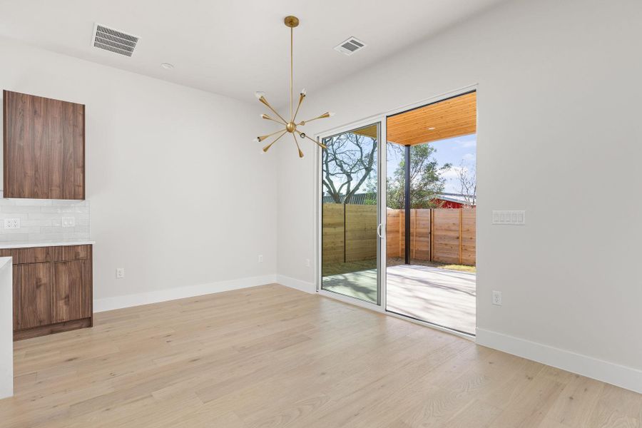 Unfurnished dining area featuring visible vents, baseboards, and light wood-style floors