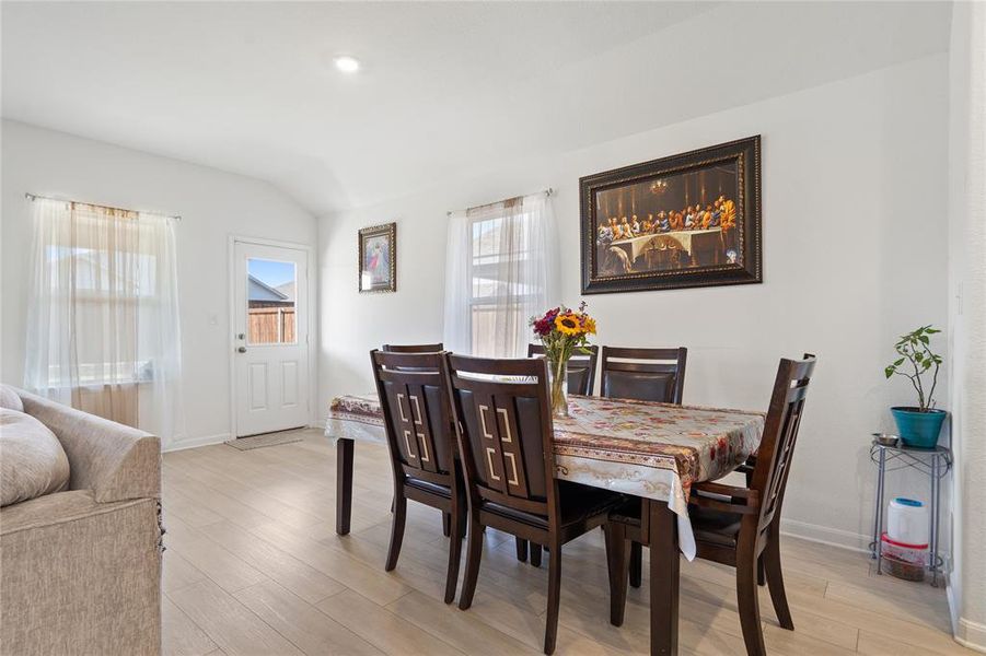 Dining space featuring light wood-style floors and lofted ceiling