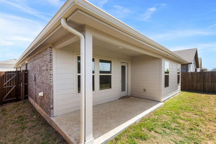 Rear view of house featuring a fenced backyard, a patio area, brick siding, and a gate Rear view of house featuring a fenced backyard, a patio area, brick siding, and a gate