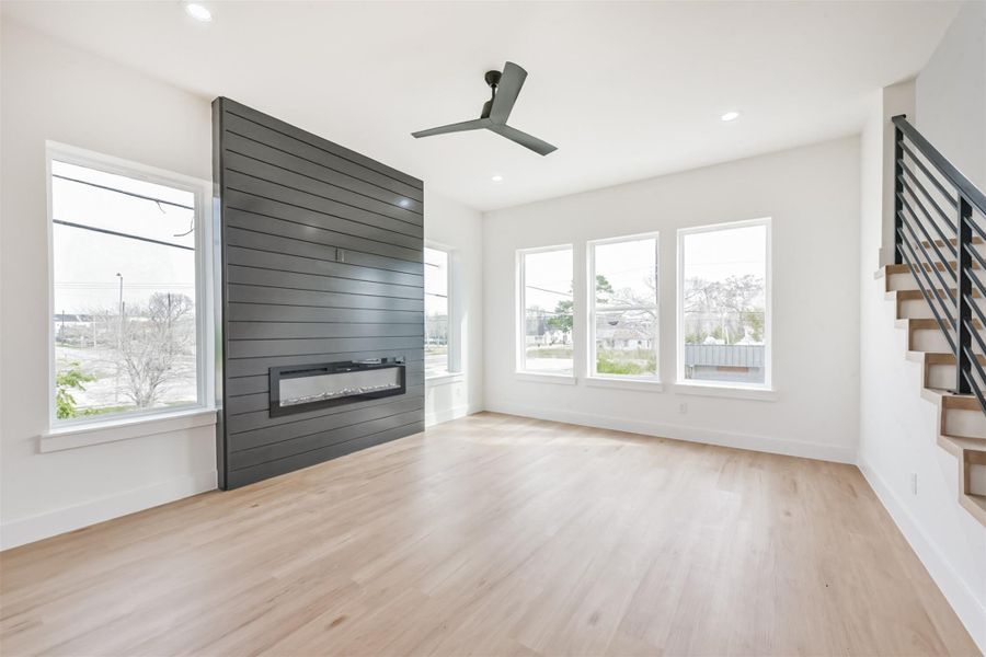 The living room has a built in electric fireplace on a wood panel accent wall.