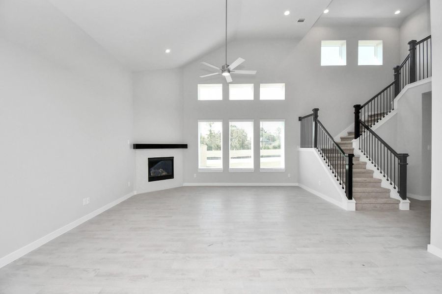Welcome family and guests to your charming living room! With its high ceilings, recessed lighting, ceiling fan, custom paint, beautiful flooring, and large windows that let in abundant natural light, this room is perfect for gatherings. Sample photo of completed home with similar floor plan. Actual colors and selections may vary. Welcome family and guests to your charming living room! With its high ceilings, recessed lighting, ceiling fan, custom paint, beautiful flooring, and large windows that let in abundant natural light, this room is perfect for gatherings. Sample photo of completed home with similar floor plan. Actual colors and selections may vary.