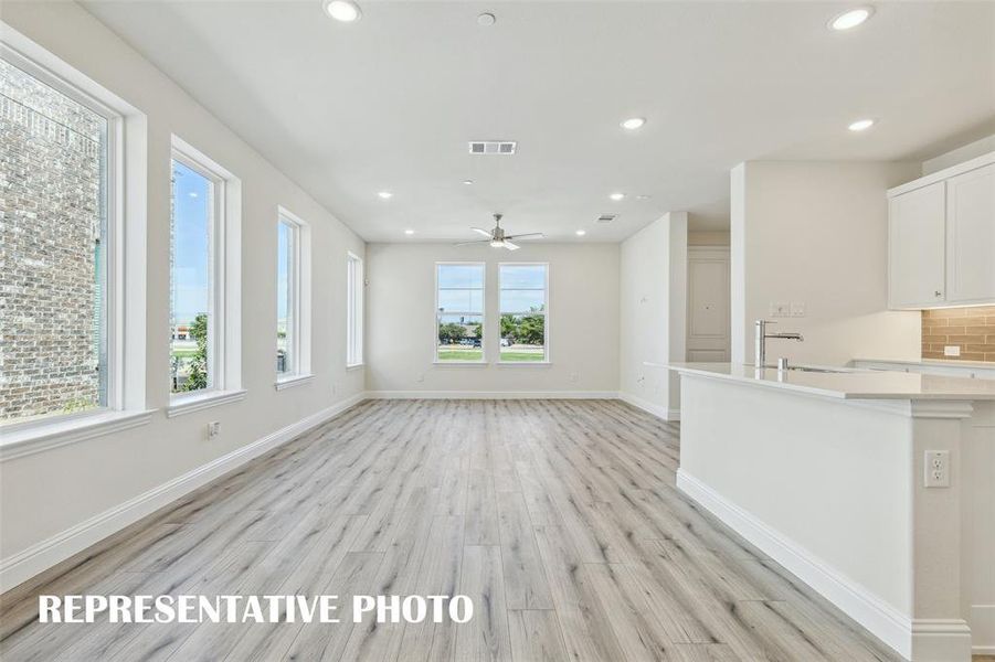 Light, bright and airy, this open concept kitchen-dining-family room is everything you have been searching for in a look and leave lifestyle home!  REPRESENTATIVE PHOTO