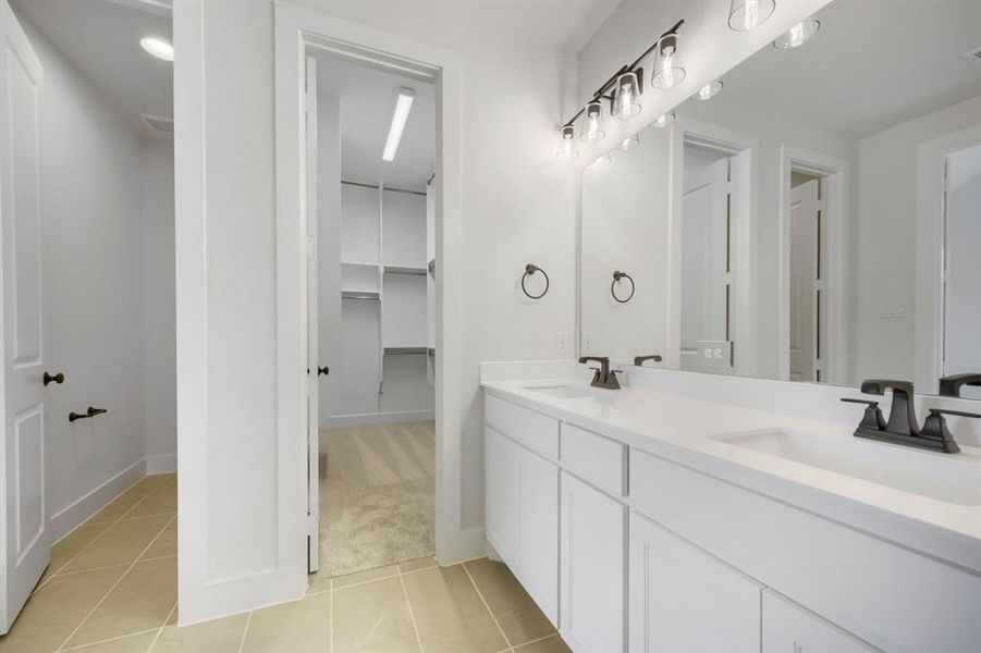 Dual vanity with white cabinetry and countertops Dual vanity with white cabinetry and countertops