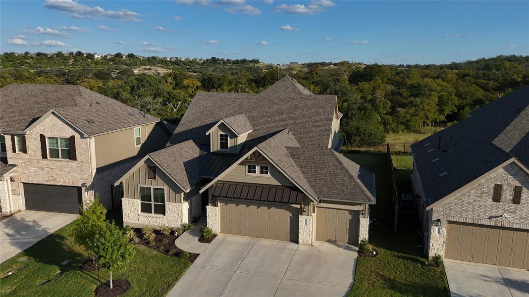 View of front of house with a standing seam roof, a metal roof, stone siding, driveway, and board and batten siding View of front of house with a standing seam roof, a metal roof, stone siding, driveway, and board and batten siding