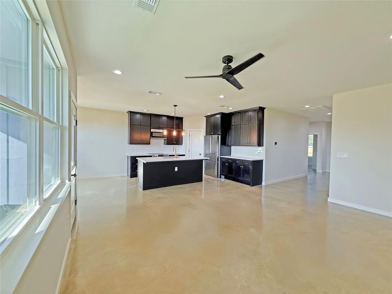 Living room with polished concrete floors, a ceiling fan, and recessed lighting