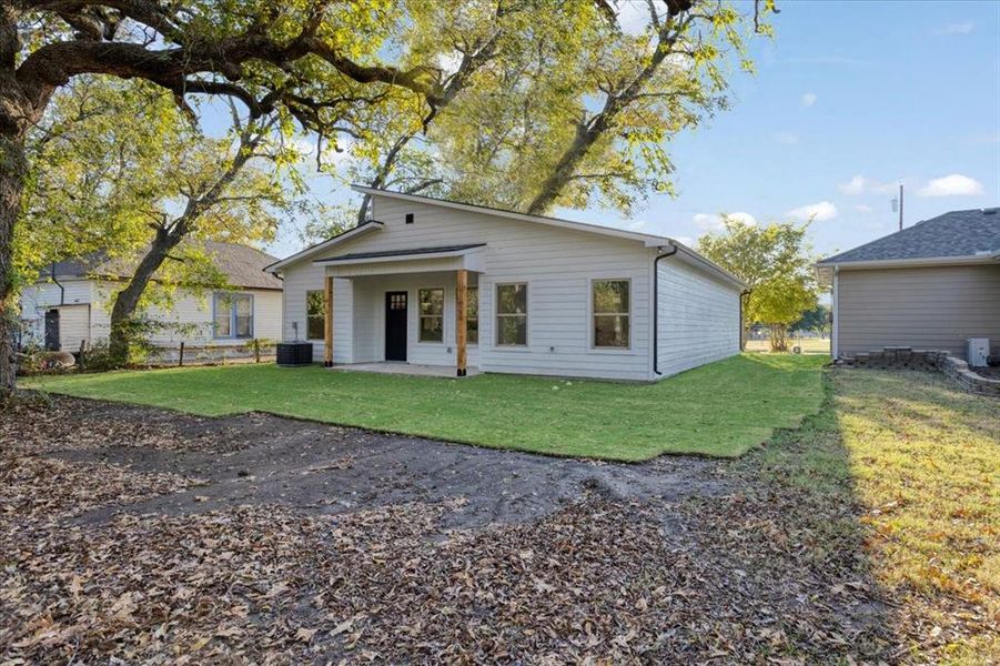 View of front of house with a front yard, a patio area, and central AC unit