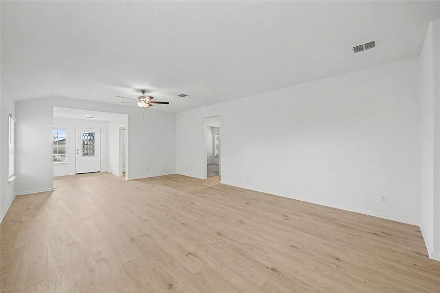 Wood flooring and soaring vaulted ceilings create an inviting atmosphere in this open living space.