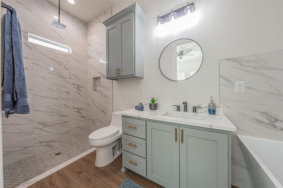 Full bath featuring a tile shower, vanity, dark wood-style floors, a tub to relax in, and recessed lighting Full bath featuring a tile shower, vanity, dark wood-style floors, a tub to relax in, and recessed lighting