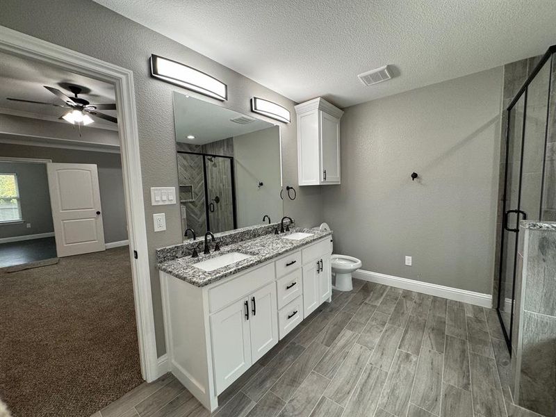 Bathroom featuring a textured ceiling, hardwood / wood-style flooring, and a shower with shower door