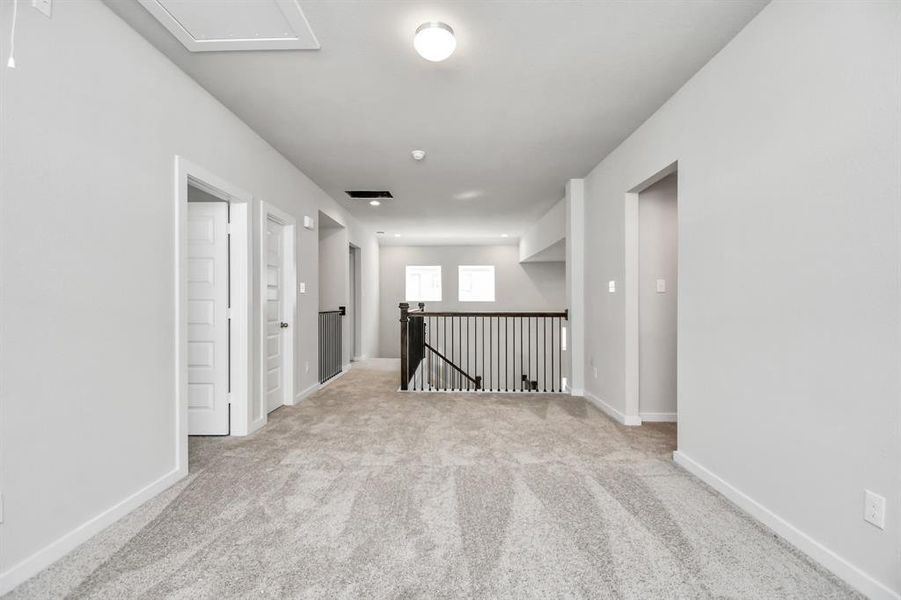 Come upstairs and relish a day of relaxation in this loft area! Ideal as an additional living space or game room, it boasts plush carpeting, high ceilings, custom paint, and windows that flood the area with abundant natural light.