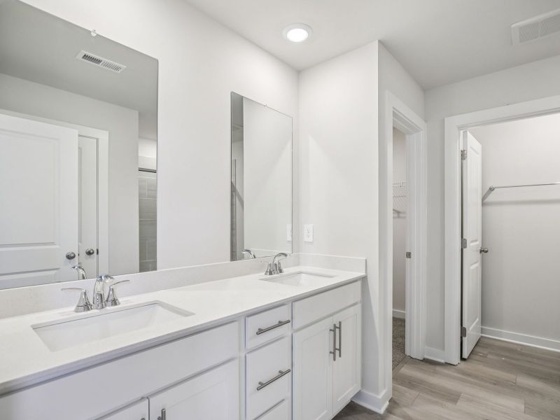 The primary bathroom offers dual vanity sinks and a walk-in shower. The primary bathroom offers dual vanity sinks and a walk-in shower.