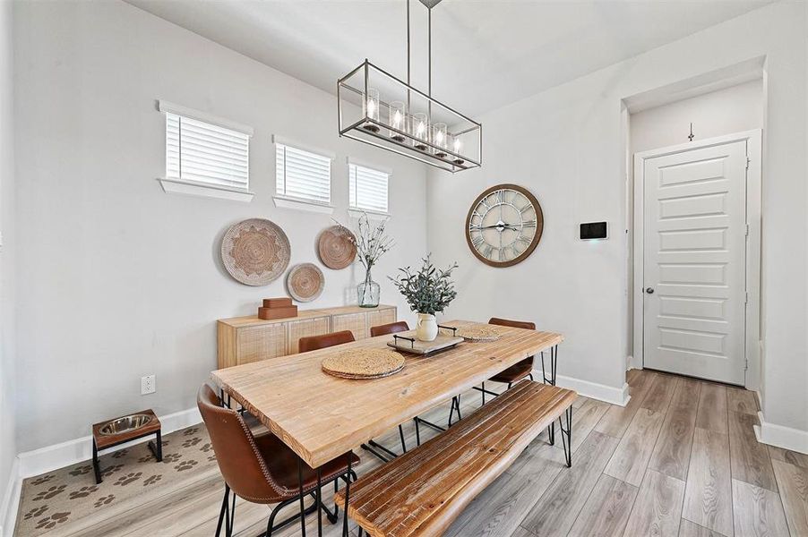 Dining room with a chandelier and light wood finished floors Dining room with a chandelier and light wood finished floors