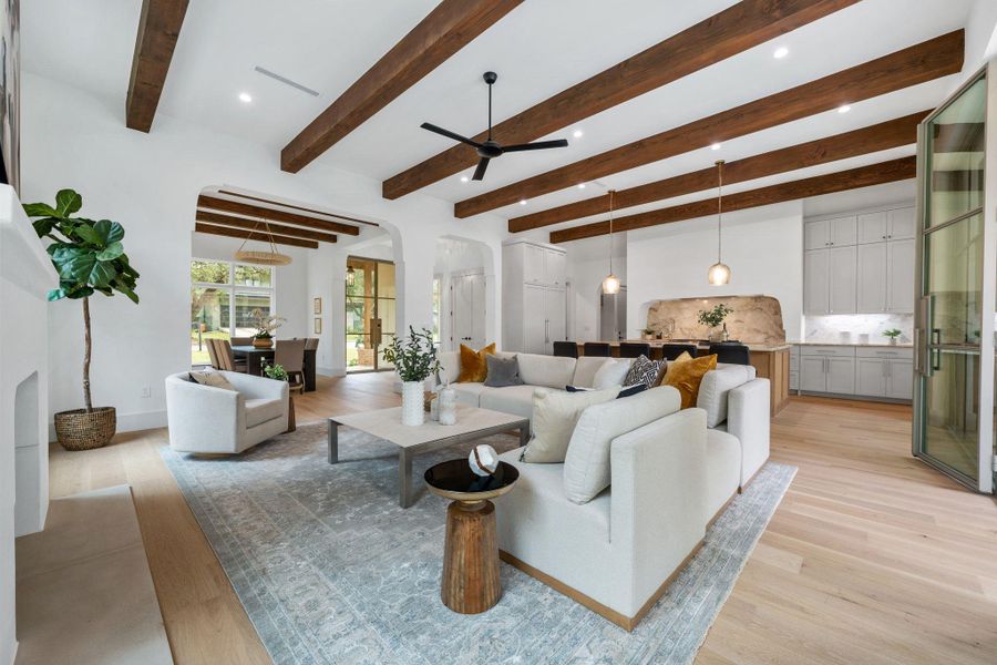 Living area featuring light wood-style floors, beam ceiling, a ceiling fan, recessed lighting, and arched walkways Living area featuring light wood-style floors, beam ceiling, a ceiling fan, recessed lighting, and arched walkways