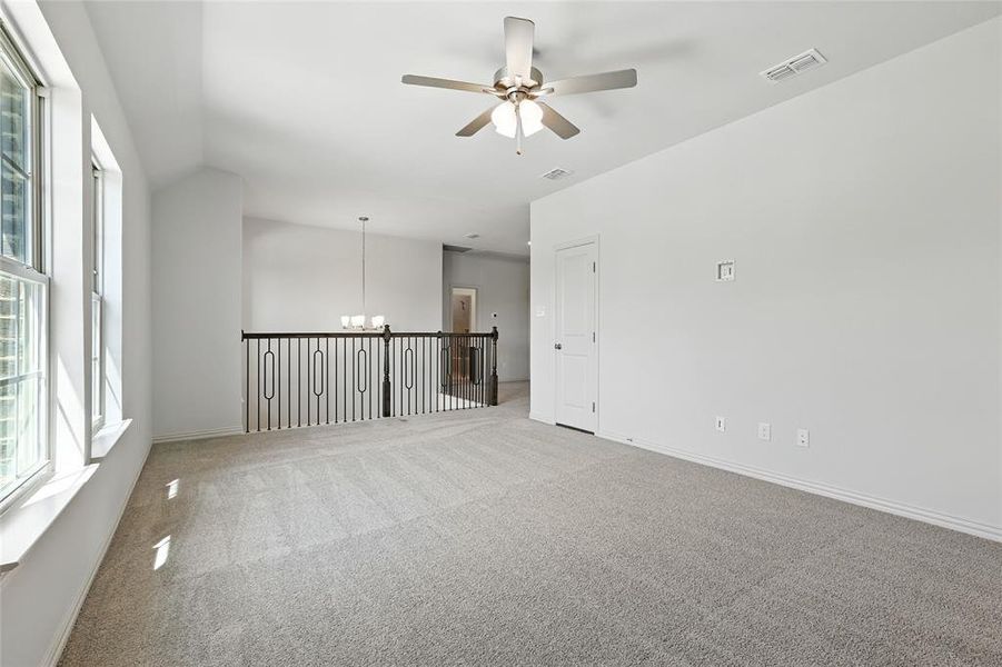 Carpeted spare room with ceiling fan and hanging lights Carpeted spare room with ceiling fan and hanging lights