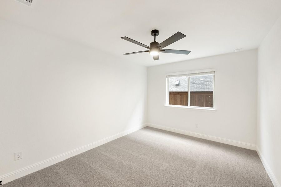Empty bedroom with gray carpet, white walls, ceiling fan with light, and single window Empty bedroom with gray carpet, white walls, ceiling fan with light, and single window