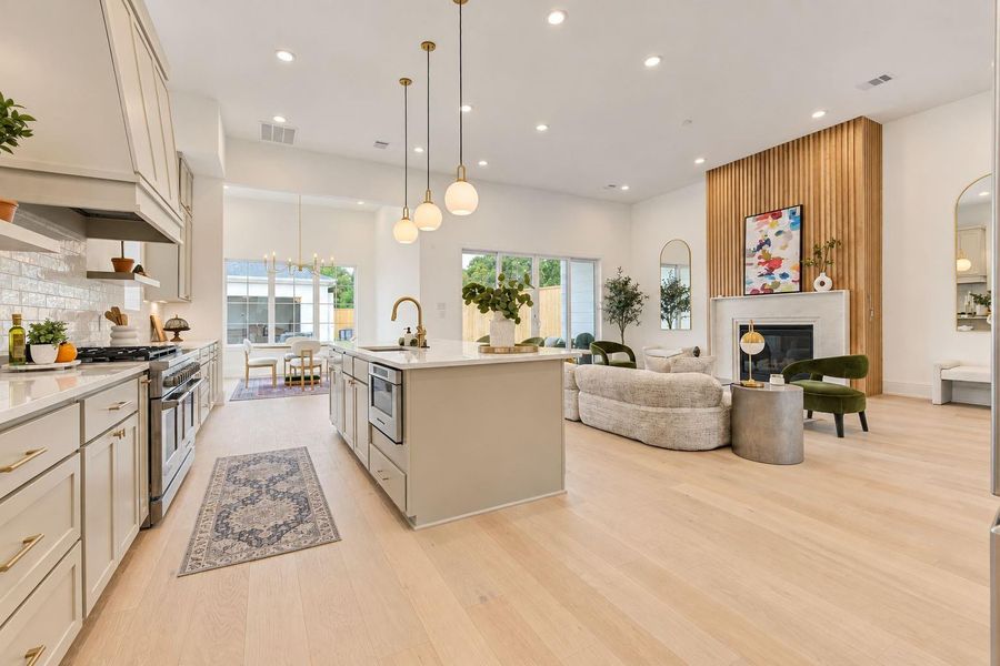 Another impressive view of the chef-inspired kitchen highlighting the oversized island, quartz countertops, sleek cabinetry, designer pendant lighting, and generous workspace. The open-concept design creates a seamless connection to the living and dining areas—perfect for entertaining while keeping everyone connected. Another impressive view of the chef-inspired kitchen highlighting the oversized island, quartz countertops, sleek cabinetry, designer pendant lighting, and generous workspace. The open-concept design creates a seamless connection to the living and dining areas—perfect for entertaining while keeping everyone connected.