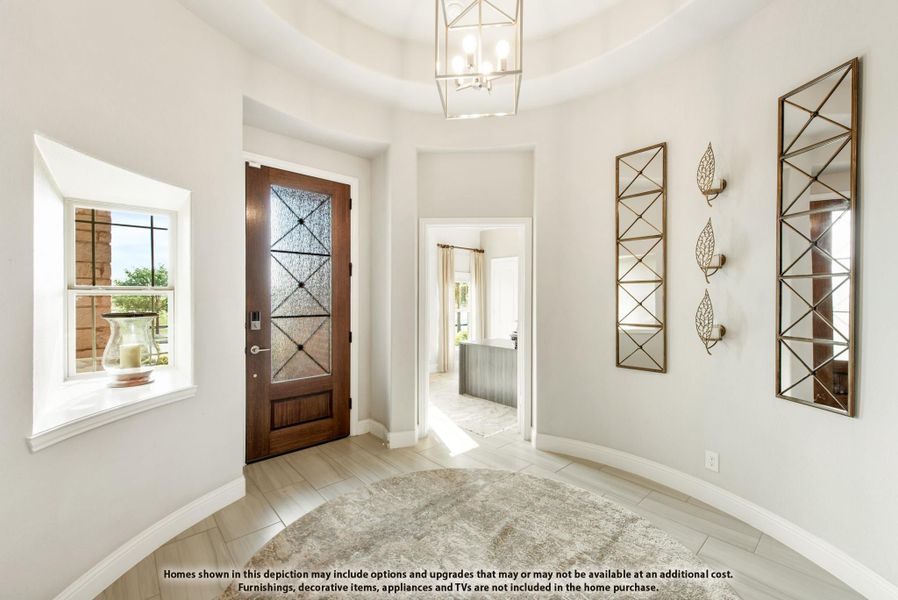 Bright home entryway with wood and glass front door, tray ceiling, pendant light, and decorative wall mirrors