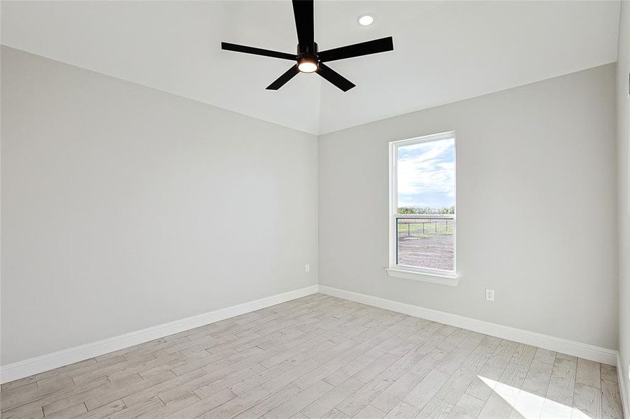 Empty room featuring light hardwood / wood-style flooring and ceiling fan