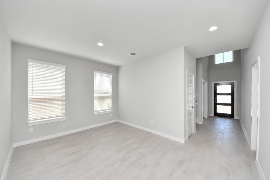 Create lasting memories with your family and friends at the dining table! This expansive dining room showcases sophisticated flooring, custom paint, and seamlessly connects to the family room and kitchen, providing an open and inviting atmosphere. Sample photo of completed home with similar floor plan. Actual colors and selections may vary.