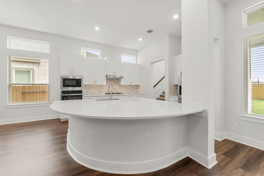 Kitchen with stainless steel oven, built in microwave, under cabinet range hood, decorative backsplash, and a sink Kitchen with stainless steel oven, built in microwave, under cabinet range hood, decorative backsplash, and a sink