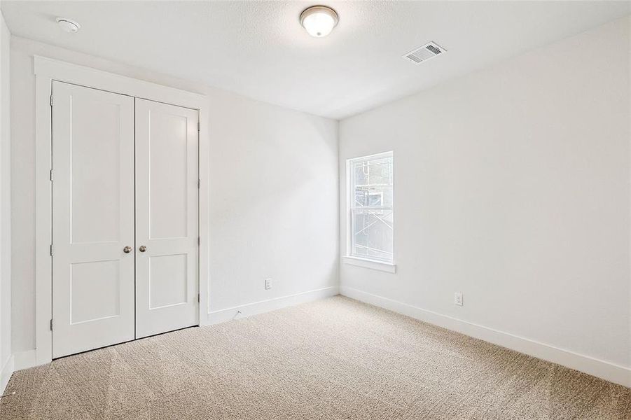 Unfurnished bedroom with a closet and light carpet