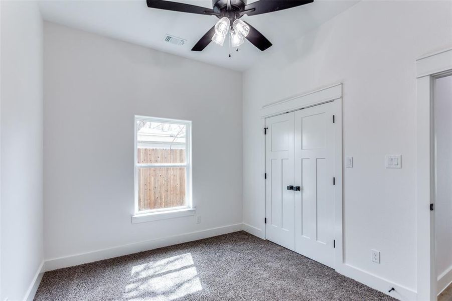 Unfurnished bedroom with carpet floors, baseboards, visible vents, and a closet