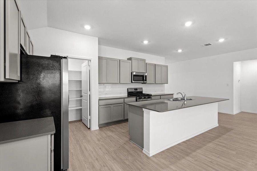 Modern kitchen features a convenient pantry and an inviting island, perfect for casual dining and entertaining. Modern kitchen features a convenient pantry and an inviting island, perfect for casual dining and entertaining.