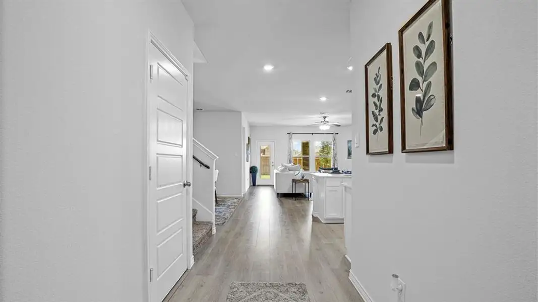 Corridor with light wood-style flooring and recessed lighting