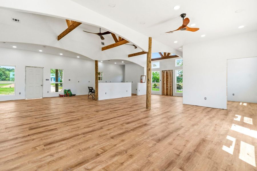 Large living room with cedar columns open to the kitchen and dining room.