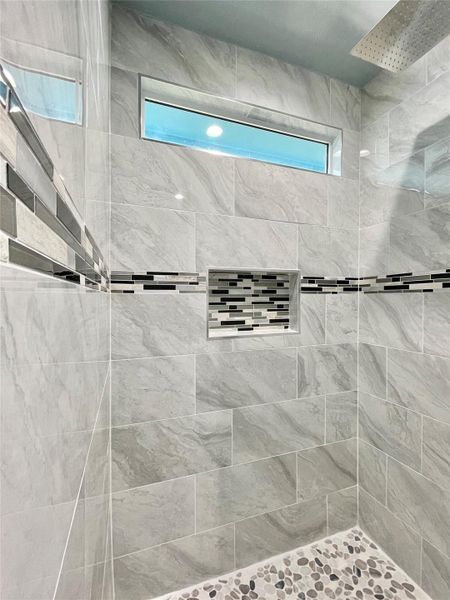 Elegant shower featuring tasteful tile work and a convenient recessed niche.