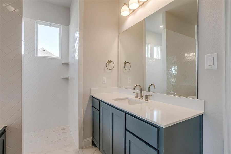 Bathroom with vanity and tiled shower