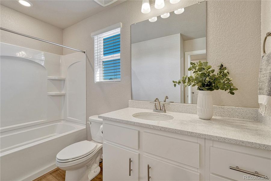Full upstairs bathroom with quartz countertop and LVP flooring.