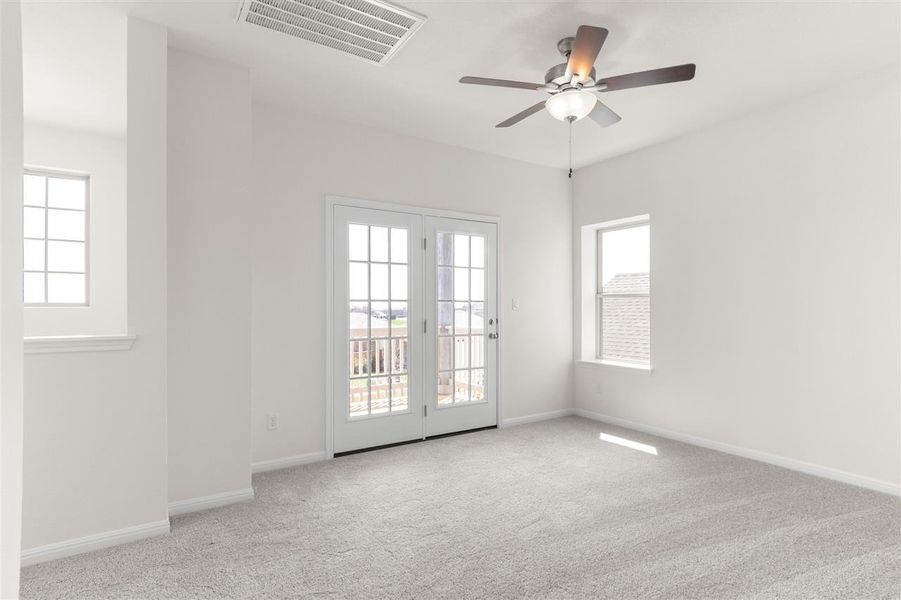 Spare room featuring carpet flooring, a ceiling fan, baseboards, and visible vents