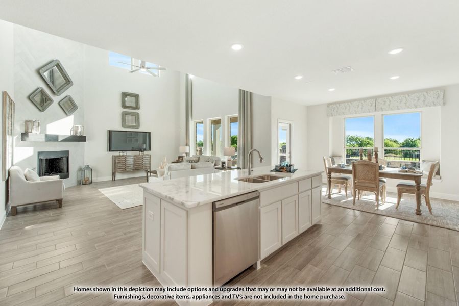 Open-concept kitchen with white island, quartz countertops, and views into dining and living areas with fireplace.