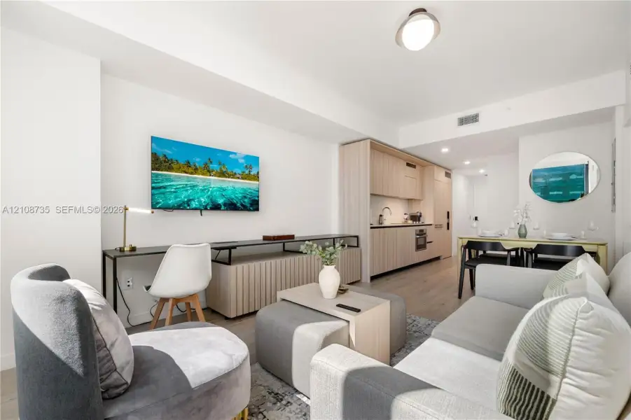 Open-concept floor plan featuring wood-finish flooring, recessed lighting, and custom light-toned cabinetry Open-concept floor plan featuring wood-finish flooring, recessed lighting, and custom light-toned cabinetry