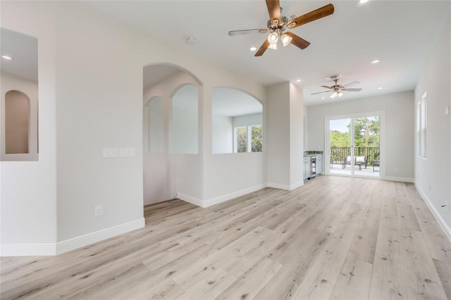 Unfurnished living room featuring ceiling fan and light wood-type flooring