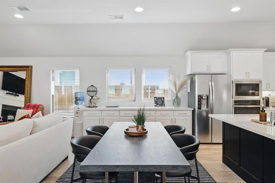 Kitchen featuring stainless steel appliances, plenty of natural light, light wood-style floors, and visible vents