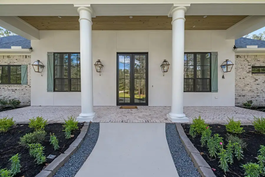 Inviting front elevation featuring a charming walkway with brick pavers leading to a welcoming front porch. Highlighted by a beautiful glass front door and elegant outdoor lanterns. Inviting front elevation featuring a charming walkway with brick pavers leading to a welcoming front porch. Highlighted by a beautiful glass front door and elegant outdoor lanterns.