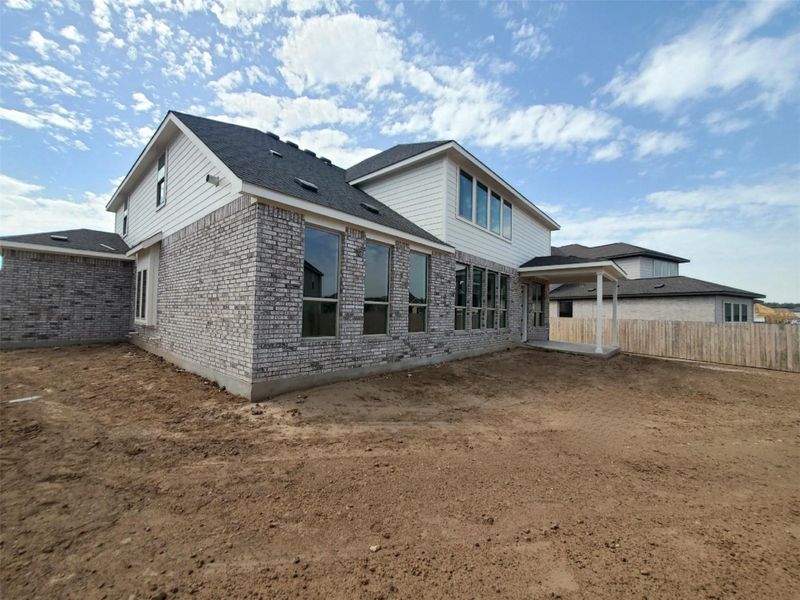 Rear view of house featuring fence and brick siding