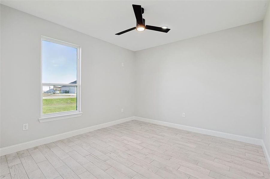 Spare room with light wood-type flooring and ceiling fan