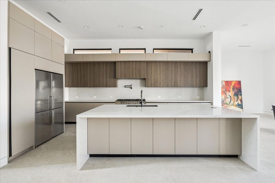 The chef’s kitchen boasts imported Italian cabinetry, quartz countertops, and a generous island with ample storage.