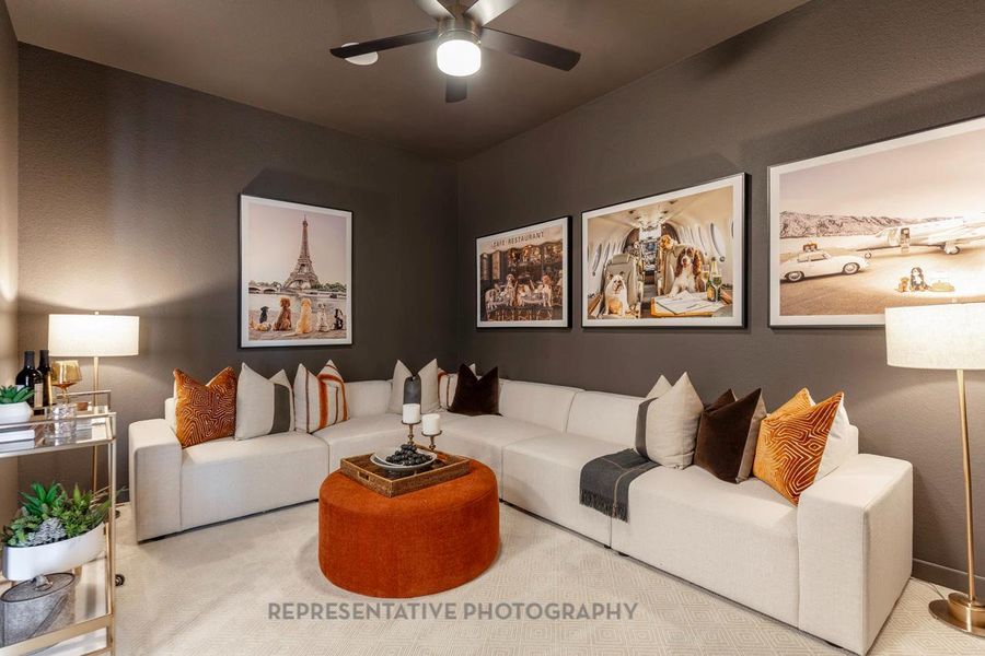Carpeted living area with a ceiling fan Carpeted living area with a ceiling fan
