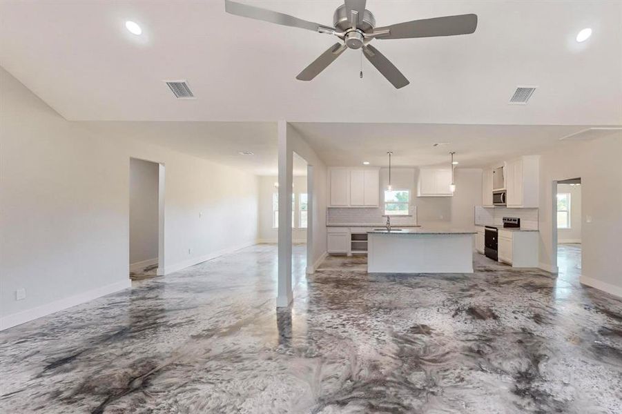 Unfurnished living room with ceiling fan and sink