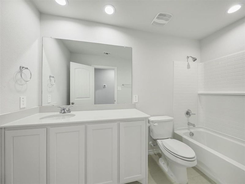 Bathroom with recessed lighting, washtub / shower combination, vanity, toilet, and tile patterned flooring Bathroom with recessed lighting, washtub / shower combination, vanity, toilet, and tile patterned flooring