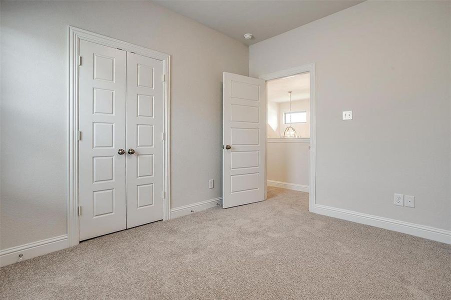 Unfurnished bedroom with a closet and light colored carpet